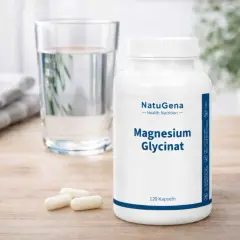 Flasche NatuGena Magnesium Glycinat neben einem Glas Wasser. Die positive magnesium bisglycinat wirkung für den Körper wird hier symbolisch dargestellt.
