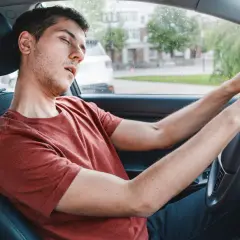 Ein Mann im Auto schläft fast ein, ein gefährlicher sekundenschlaf auf der arbeit.