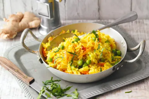 Gelber Reis mit Erbsen und Karotten, ein leckeres Gericht, das an Kurkuma gegen Gelenkschmerzen Rezepte erinnert.