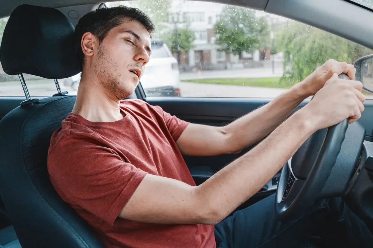 Ein Mann im Auto schläft fast ein, ein gefährlicher sekundenschlaf auf der arbeit.